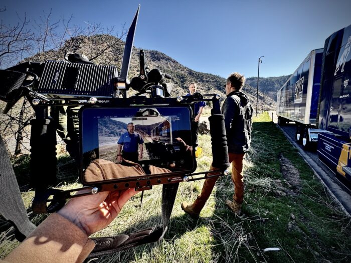 A professional video production company working on-location, with a screen in the foreground.