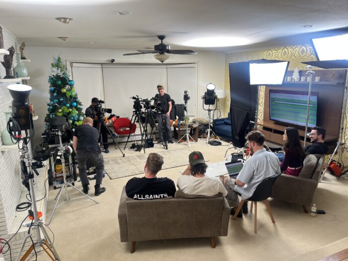 Subjects in chairs are filmed by a video production team